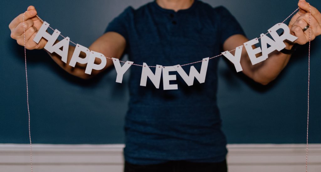 A person holding up a Happy New Year cutout banner