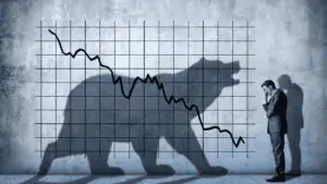 Silhouette of a bear over a graph that is trending down. A facepalming man in a suit is standing next to the graph.
