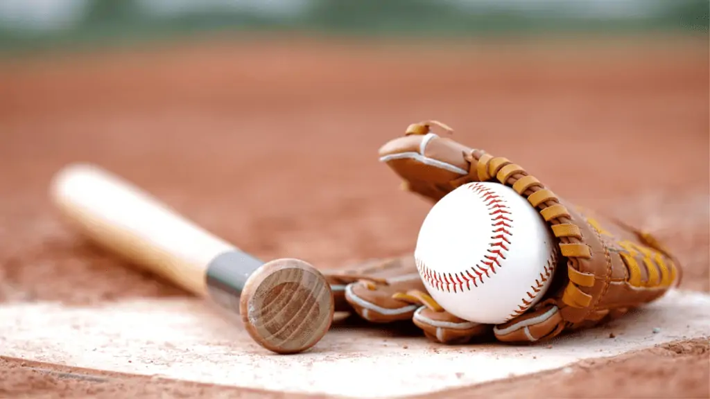 Baseball bat, ball, and glove placed together on a base