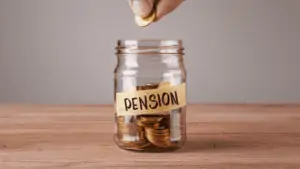 Someone dropping a coin into a jar labeled pension